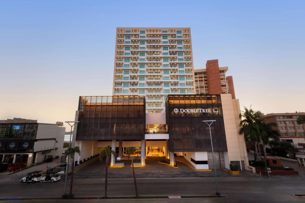 um edifício alto no meio de uma cidade em DoubleTree by Hilton Mazatlan, SIN em Mazatlán