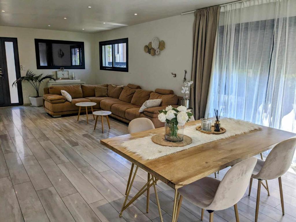 een woonkamer met een tafel en een bank bij La Villa Blanca Montpellier Piscine & proximité Mer in Saint-Jean-de-Védas