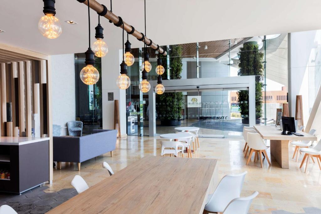 a restaurant with a wooden table and white chairs at Hilton Garden Inn Mexico City Santa Fe in Mexico City