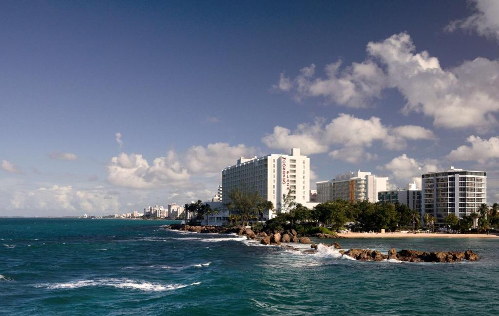 uma vista para uma praia com edifícios e o oceano em The Condado Plaza Hilton em San Juan