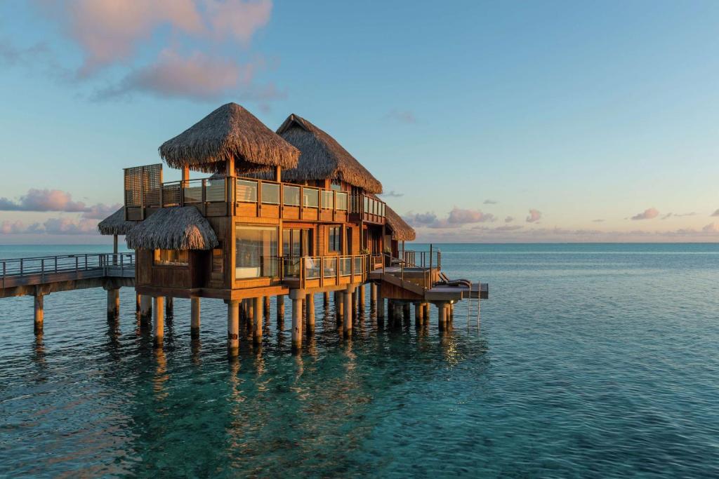 a house on a pier in the water at Conrad Bora Bora Nui in Bora Bora