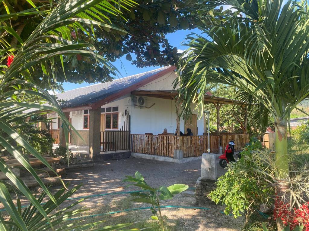 uma pequena casa branca com uma cerca em Rocky Homestay Lakey em Huu