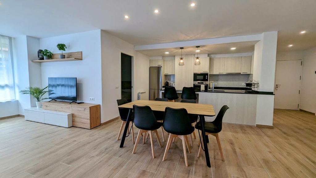 Hydros في ريبول: مطبخ وغرفة معيشة مع طاولة وكراسي خشبية