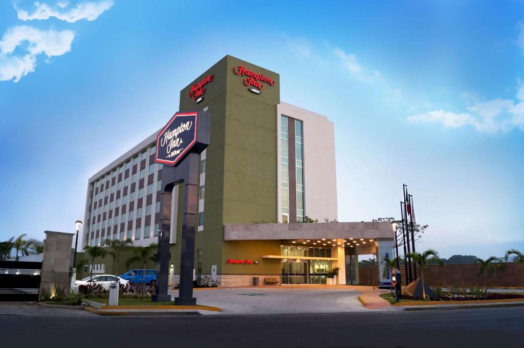 um edifício de hotel com uma placa em frente em Hampton Inn by Hilton Villahermosa em Villahermosa