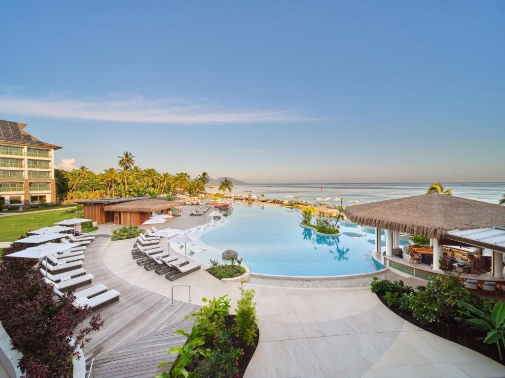 an aerial view of a resort with a swimming pool and the ocean at Hilton Hotel Tahiti in Papeete