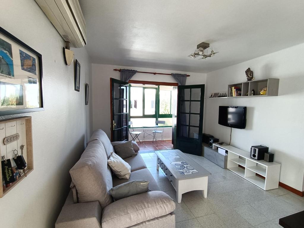 ein Wohnzimmer mit einem Sofa und einem Tisch in der Unterkunft Apartamento ANTOSOL in Playa Honda