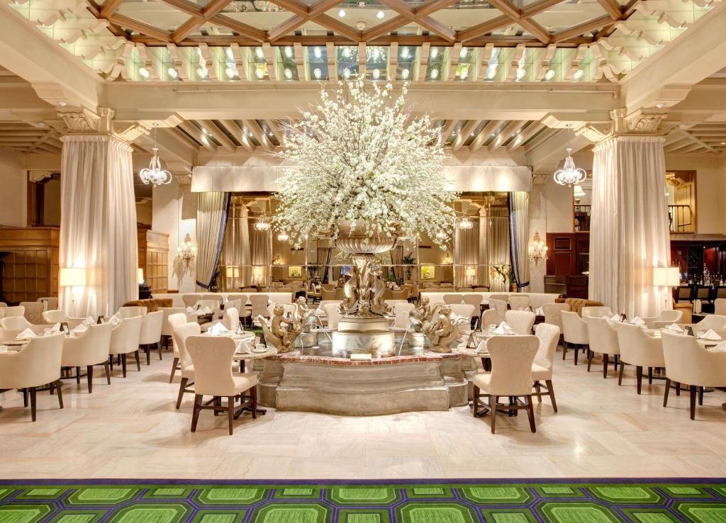 um salão de banquetes com um lustre e mesas e cadeiras em The Drake Hotel em Chicago