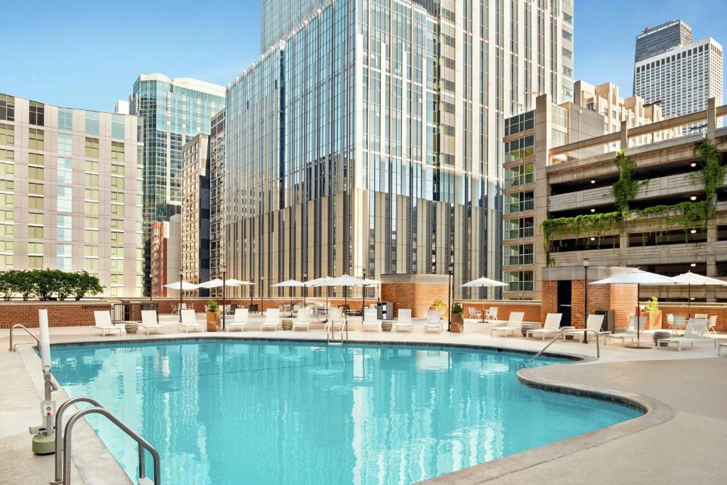a large pool with chairs and umbrellas in a city at DoubleTree by Hilton Chicago Magnificent Mile in Chicago