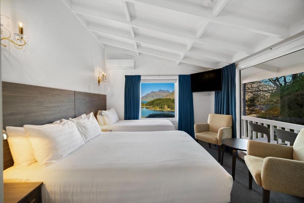 ein Hotelzimmer mit einem großen Bett und einem Balkon in der Unterkunft Lakeview Colonial Motel in Queenstown