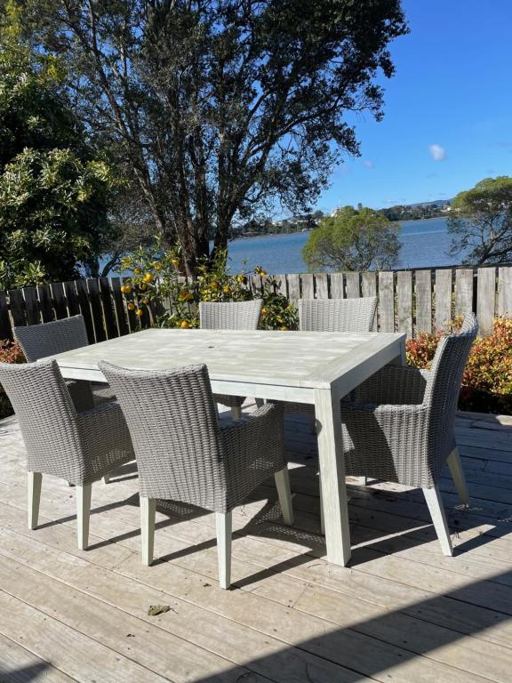 einen weißen Tisch und Stühle auf einer Terrasse in der Unterkunft Bach on Daisy in Tauranga