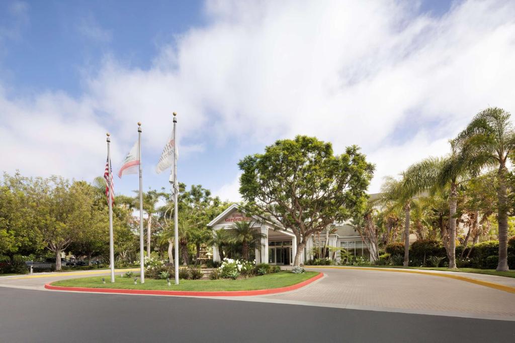 een huis met twee vlaggen op een weg bij Hilton Garden Inn LAX - El Segundo in El Segundo