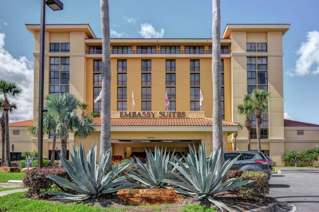 um edifício de hotel com palmeiras em frente em Embassy Suites by Hilton Orlando International Drive Convention Center em Orlando