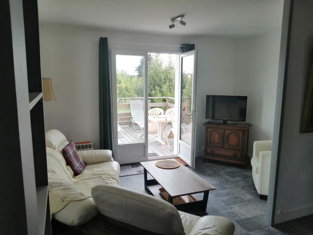 a living room with a couch and a table at Maison au calme à 5 minutes du centre-ville 2 nuitées minimum in Saint-Pourçain-sur-Sioule