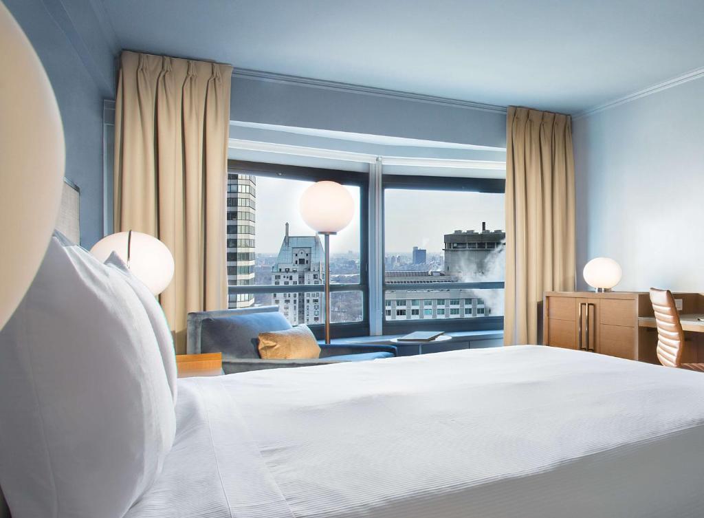 a bedroom with a bed and a large window at New York Hilton Midtown in New York