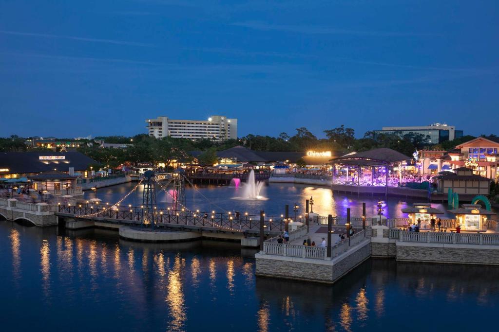 uma ponte sobre um rio com uma cidade à noite em Hilton Orlando Lake Buena Vista - Disney Springs™ Area em Orlando