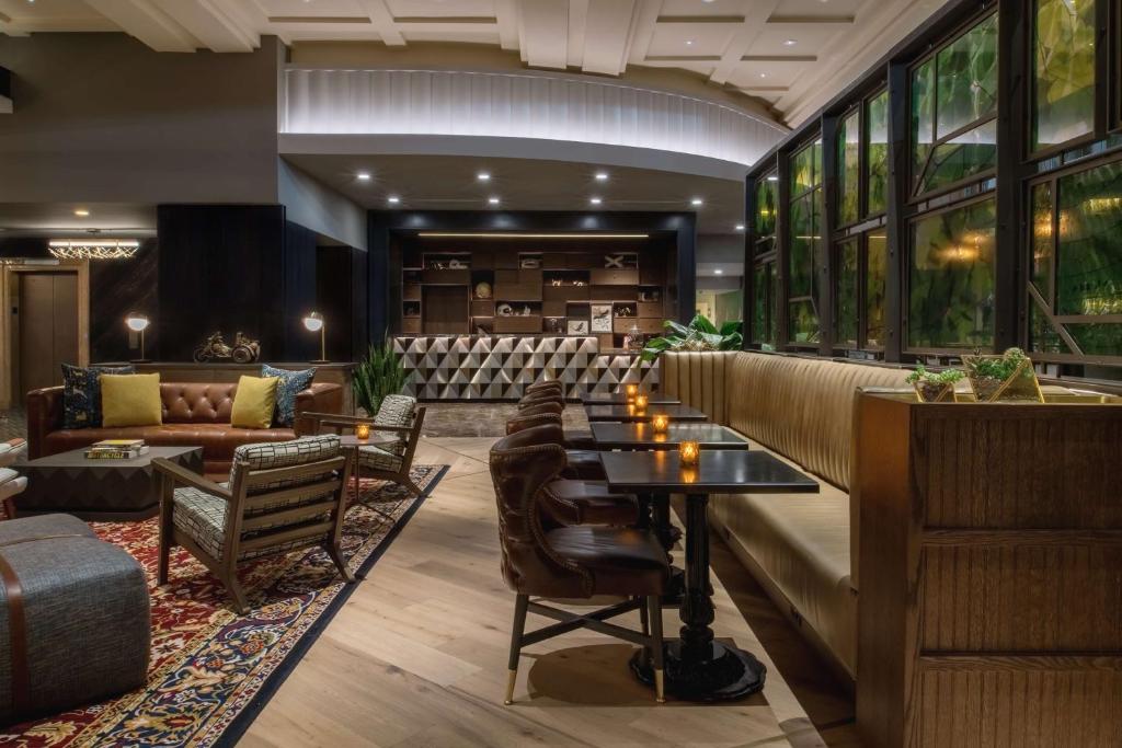 a lobby of a hotel with tables and chairs at The Duniway Portland, A Hilton Hotel in Portland