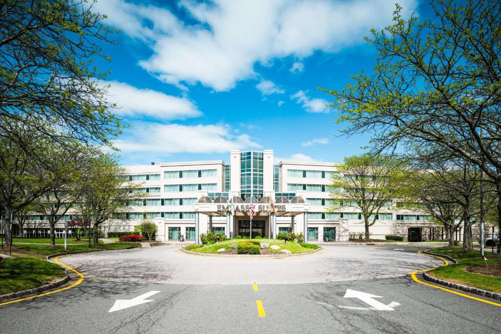 an empty parking lot in front of a white building at Embassy Suites Parsippany in Parsippany