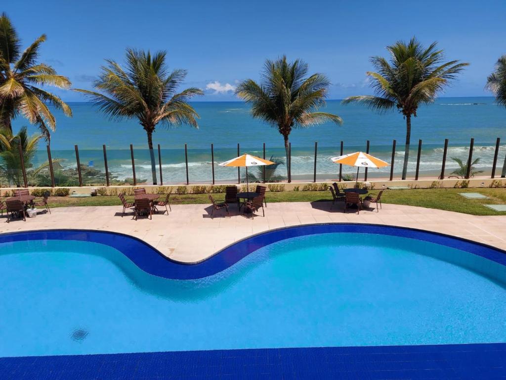 a swimming pool with a view of the beach at Tabatinga Flat - Beira Mar in Conde