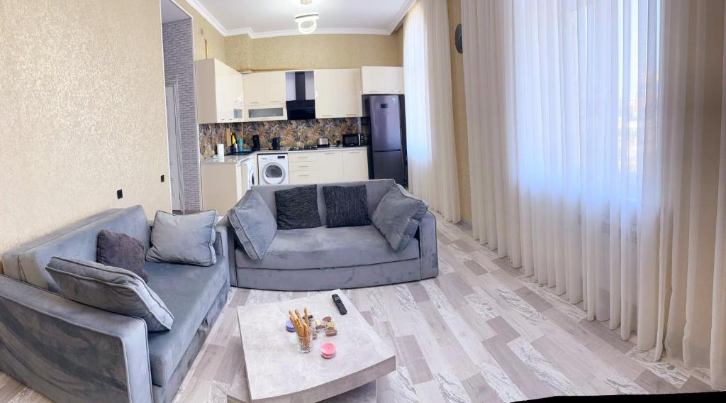 uma sala de estar com dois sofás e uma mesa em Very comfortable apartment, convenient location! em Baku