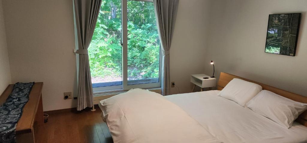 Postel nebo postele na pokoji v ubytování El Cosmo Lodge, Niseko