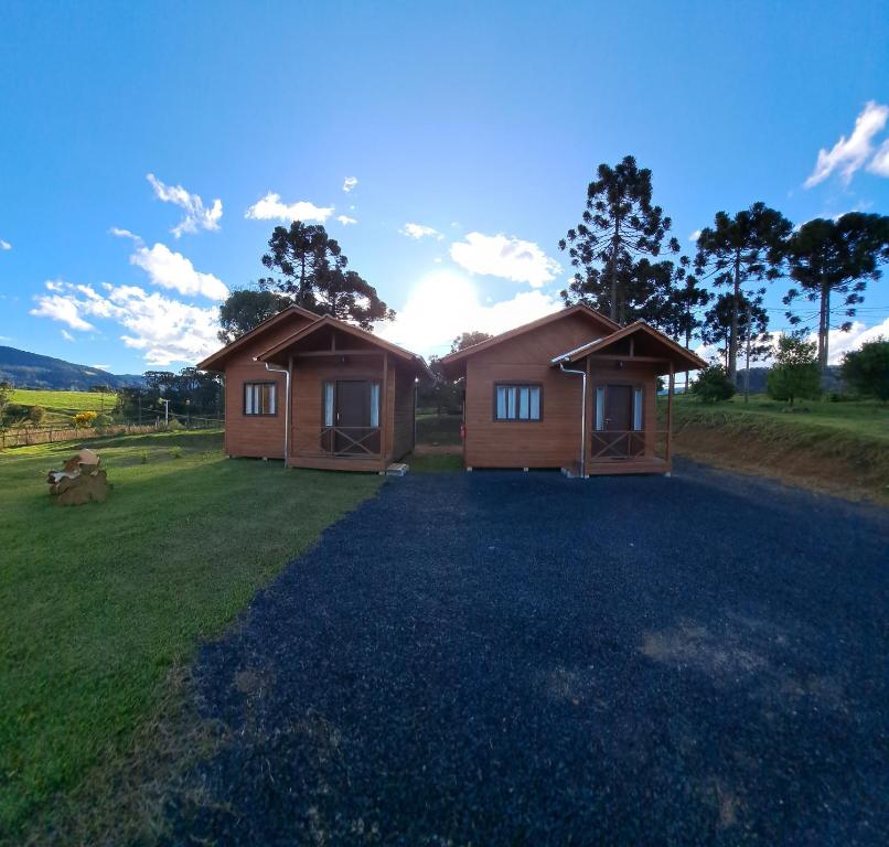 2 cottages dans un champ avec une cour dans l'établissement Chalés Sossego da Serra, à Urubici