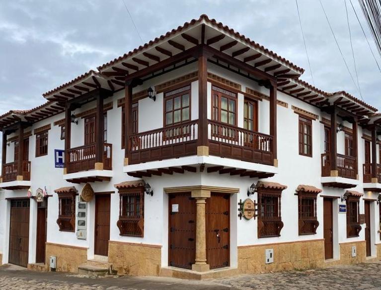 een groot wit gebouw met houten balkons bij Muisca Hotel Villa de Leyva in Villa de Leyva