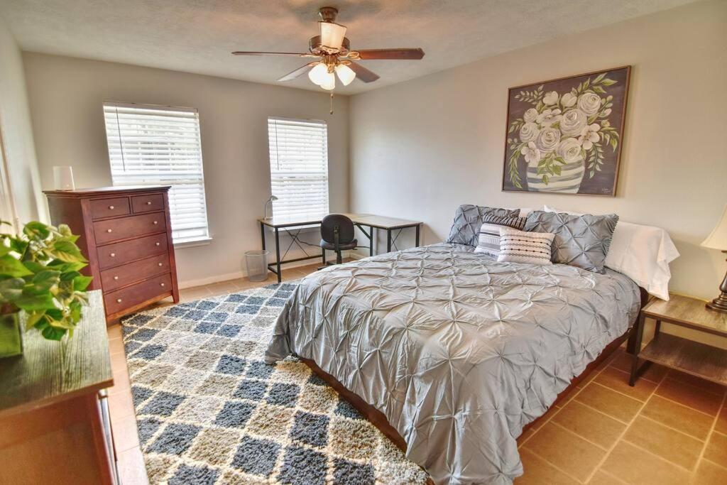 - une chambre avec un lit et un ventilateur de plafond dans l'établissement Centrally Located Parking Included, à Houston