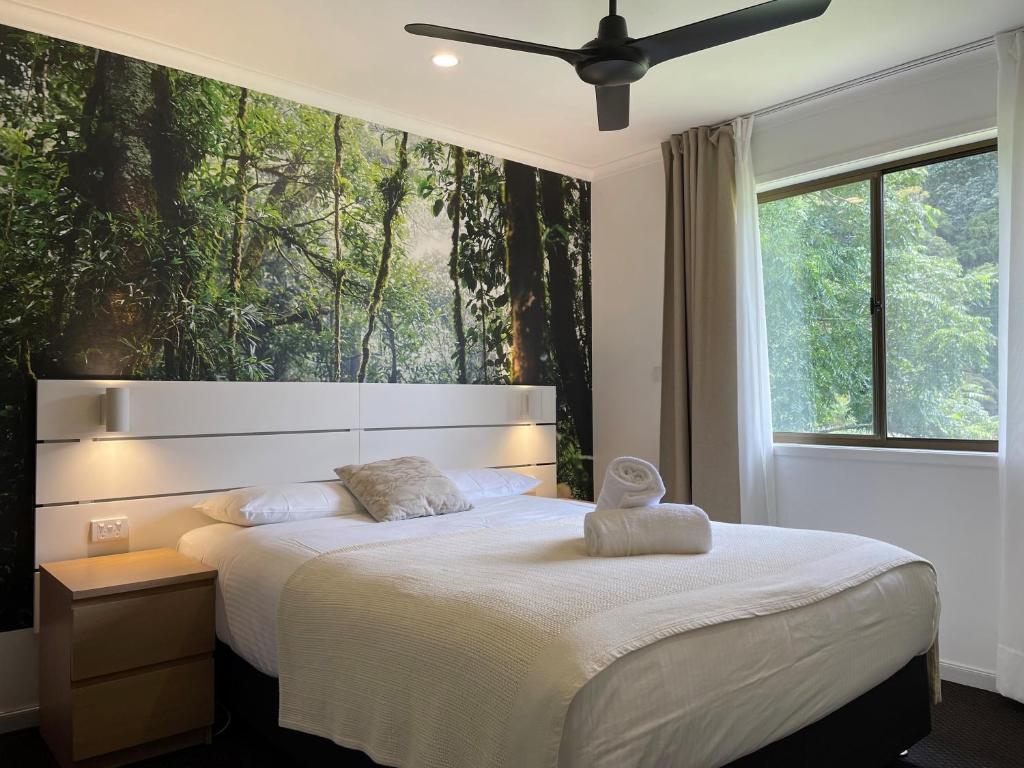 a bedroom with a bed with a large window at Bunya Mountains Tavern 