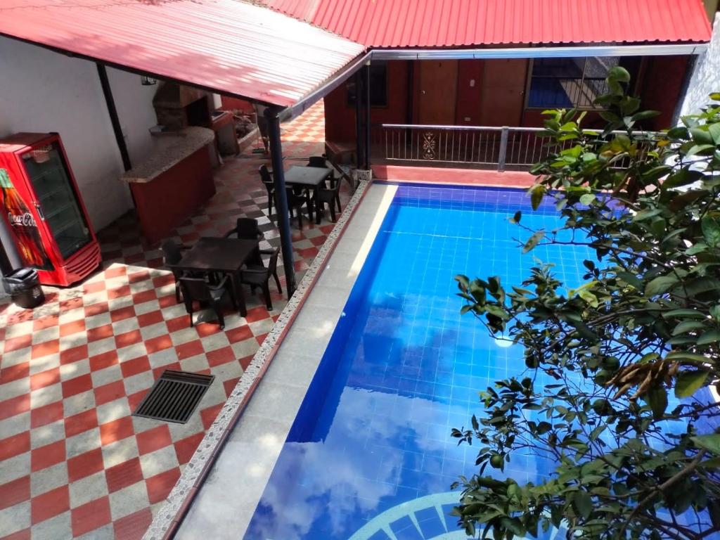 una piscina en una casa con techo rojo en Hotel la Isabela By Marbar, en Villeta