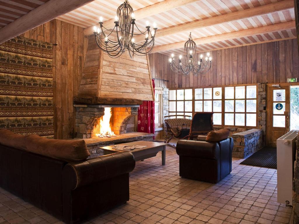 Elle comprend un salon doté d'un mobilier en cuir et d'une cheminée. dans l'établissement Chalet in Les Arcs with Heated Pool, à Arc 2000