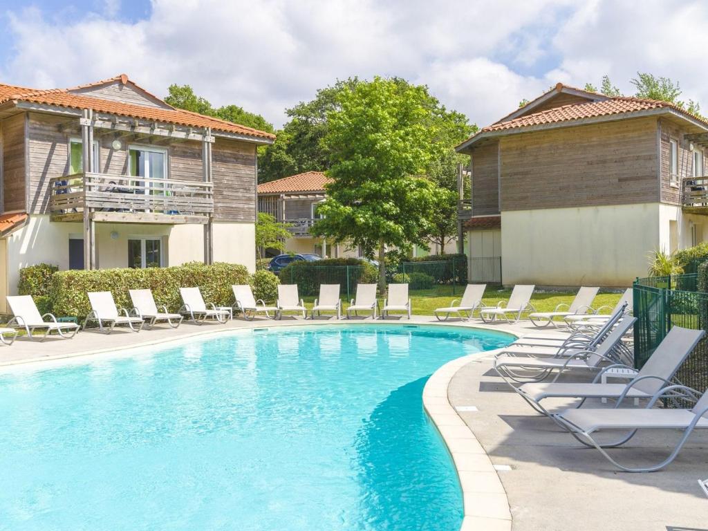 - une piscine avec des chaises longues et des chaises longues à côté d'une maison dans l'établissement Apartment in France with Lake Views, à Aureilhan
