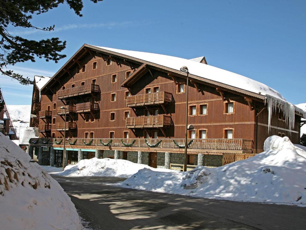 un grand bâtiment avec de la neige devant lui dans l'établissement Chalet in Paradiski with Stunning Views, à Arc 2000
