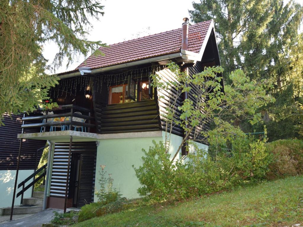 a wooden house with a balcony on the side of it at Restful Holiday Home in Vrbovsko with Garden and Barbecue in Vrbovsko