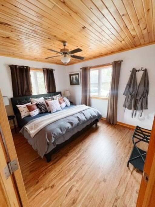 a bedroom with a bed with a wooden ceiling at Morning Lane Cottage in Mill Village
