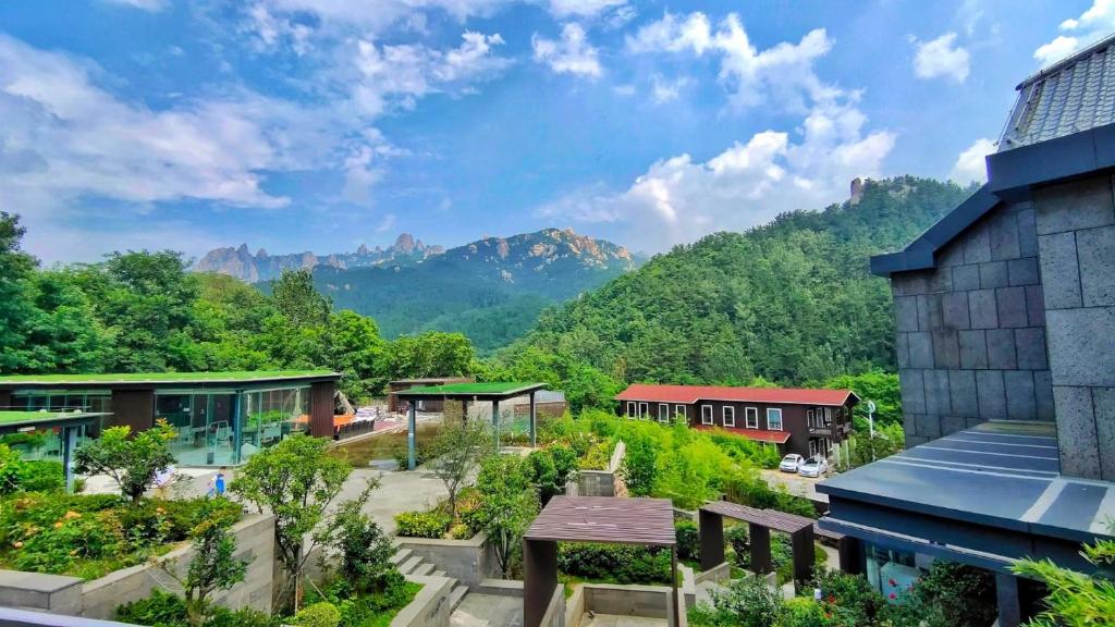 uma vista para uma estação ferroviária com montanhas ao fundo em Jiushui Heyuan Art Design Hotel em Qingdao