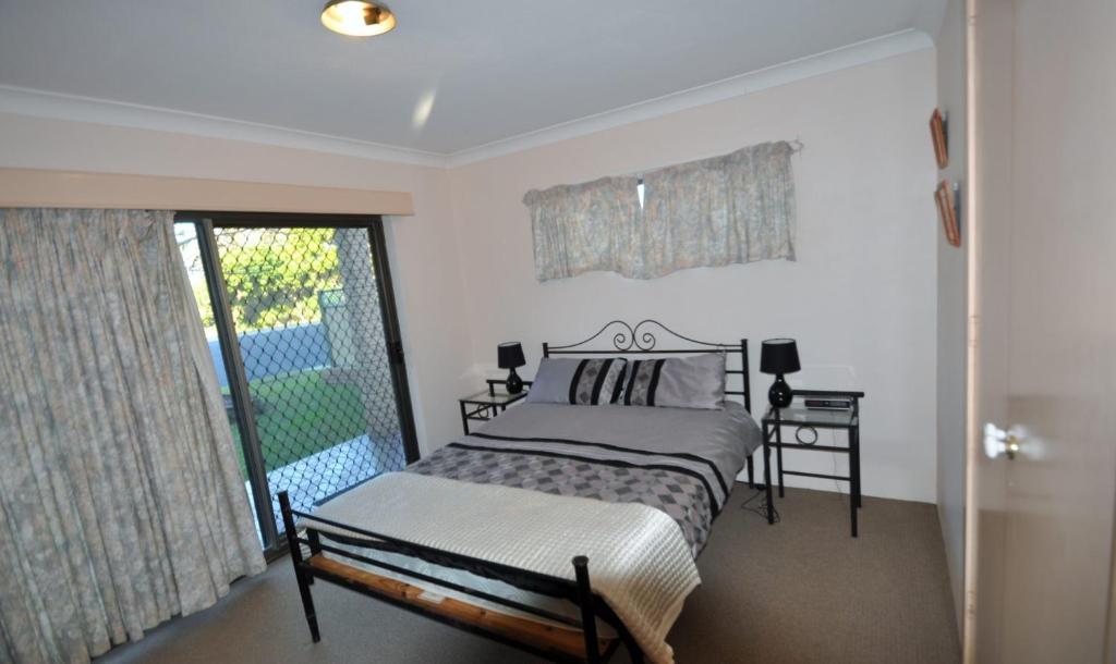 a bedroom with a bed and a large window at Pacific Palms 3, Unit 3, 9-11 Terrace Street Evans Head in Evans Head
