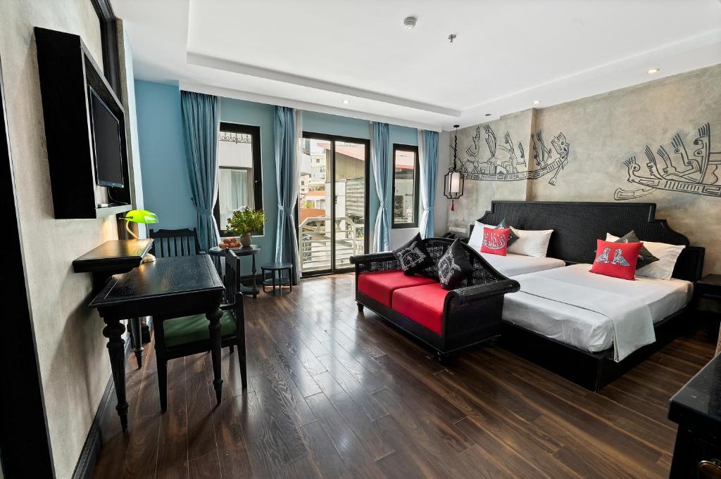 una camera con un letto e un divano rosso di 22Land Residence Hotel & Spa 52 Ngo Huyen a Hanoi