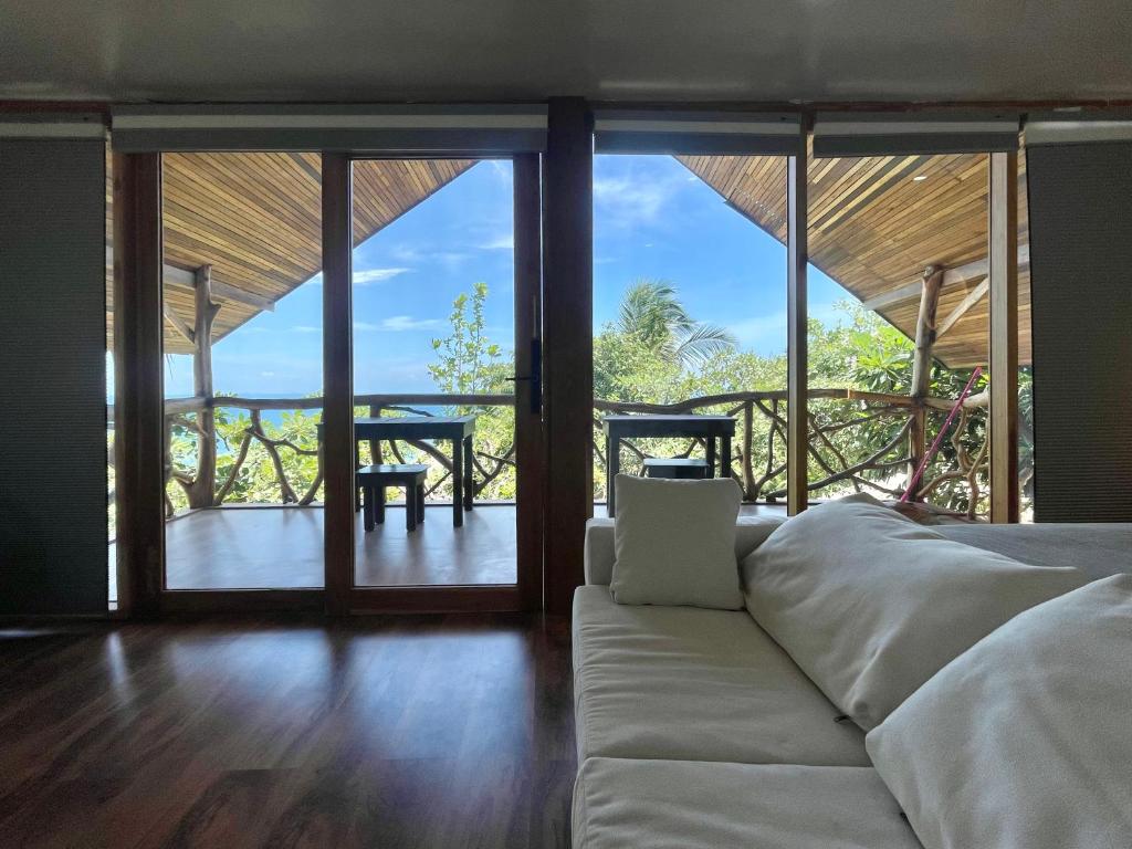 uma sala de estar com um sofá e uma varanda em Tantawan sea view residence 山海居 em Salad Beach
