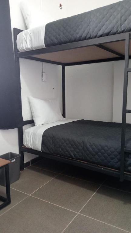 Postel nebo postele na pokoji v ubytování CHECK INN HOSTAL AEROPUERTO GDL