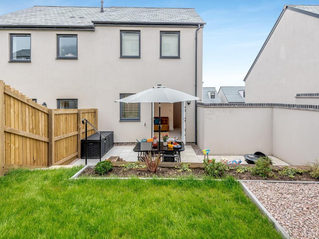 a patio with an umbrella in the backyard of a house at Phoenix House in Kingsbridge