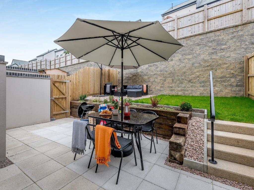 een tafel met een parasol op een patio bij Phoenix House in Kingsbridge