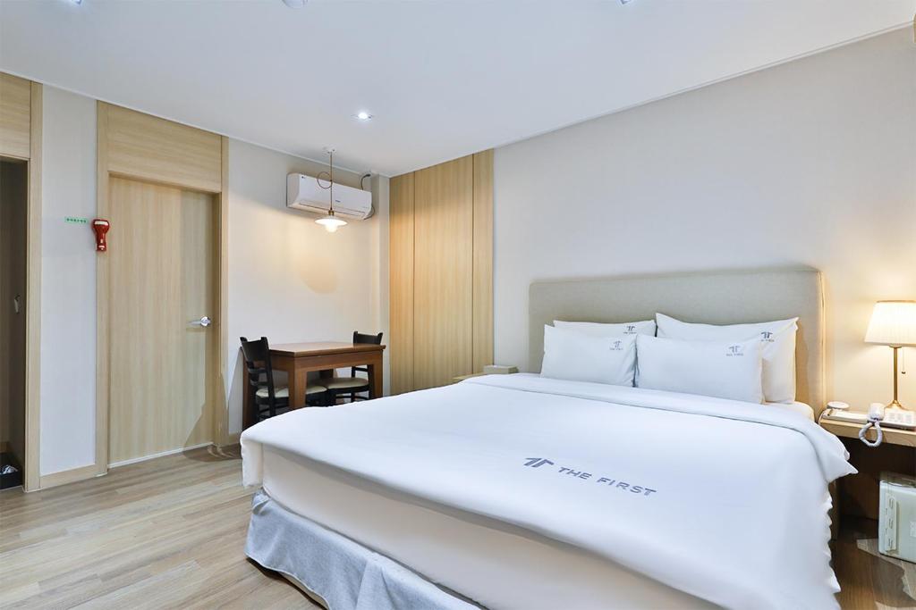 een groot wit bed in een hotelkamer bij The First Hotel in Changwon