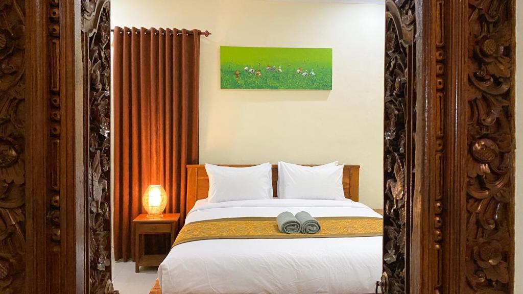 Un pat sau paturi într-o cameră la Bojig House Ubud