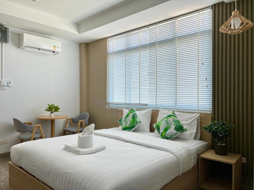 1 dormitorio con 1 cama blanca grande y ventana en The Nine Place แจ้งสนิท en Ban Nong Bua