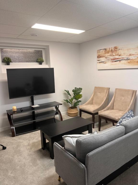 een woonkamer met een bank en een flatscreen-tv bij Basement suite in Winnipeg