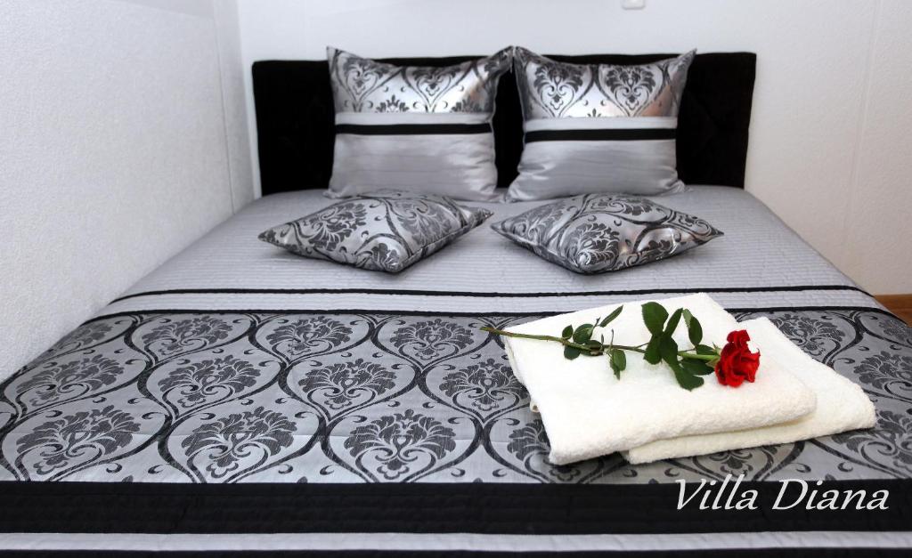 a bed with a black and white comforter and two pillows at VILLA DIANA Ustka in Ustka