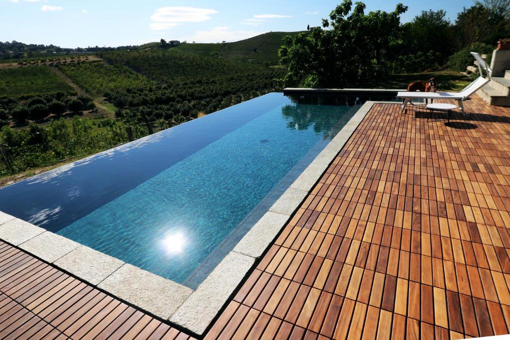 a swimming pool with a wooden floor and a pool at B&B Tricudai in Agliano Terme