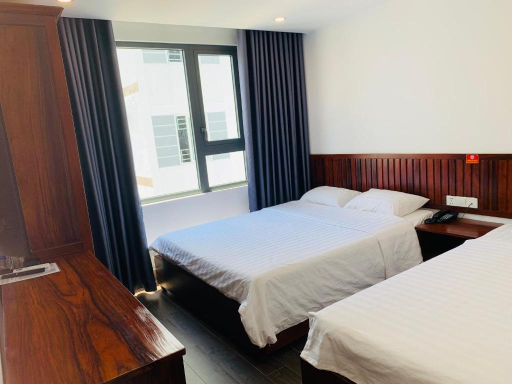 um quarto de hotel com duas camas e uma janela em Luu Gia Hotel em Nha Trang