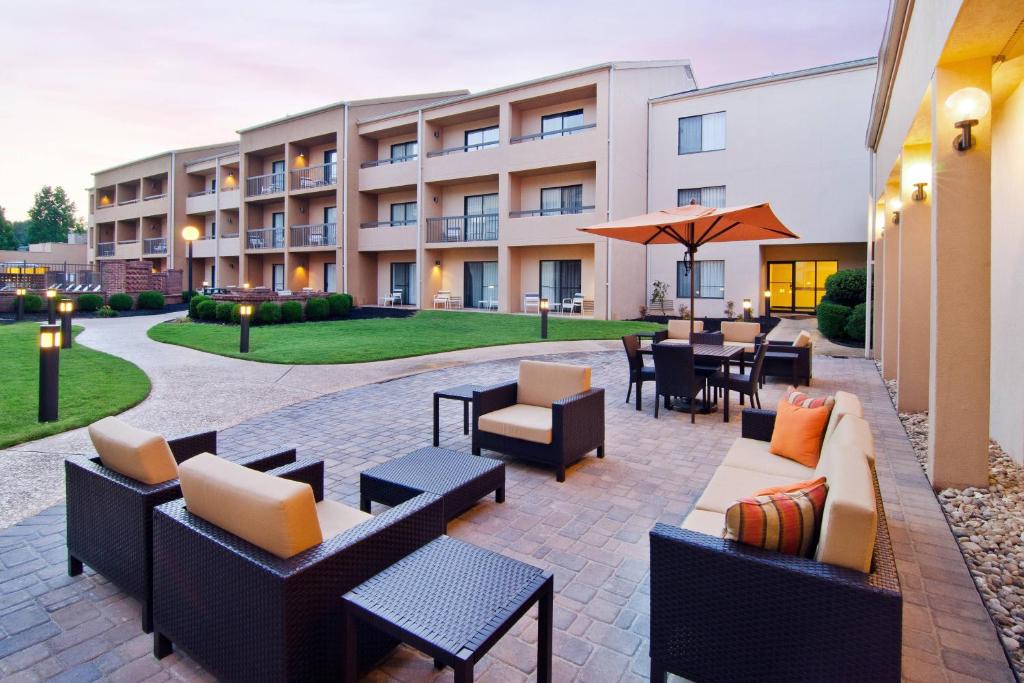 eine Terrasse mit Sofas, Tischen und Stühlen vor einem Gebäude in der Unterkunft Courtyard by Marriott Huntsville University Drive in Huntsville