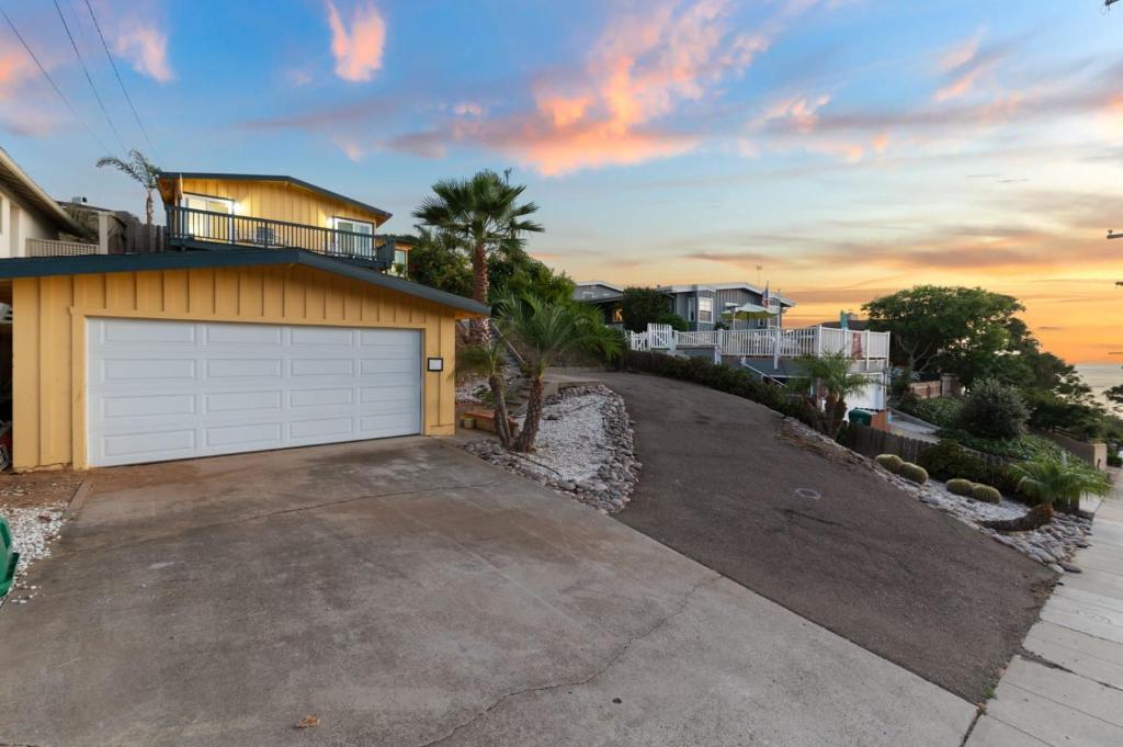 a house with a garage in front of a driveway at LOVELY Ocean View Beach House 3BR Sleeps 9 in San Diego